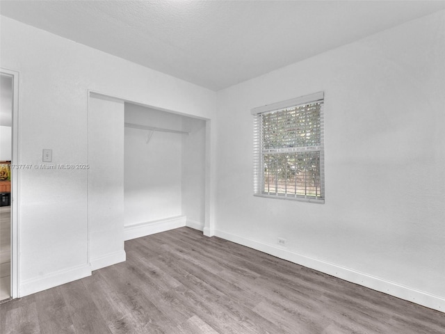 unfurnished bedroom with hardwood / wood-style flooring and a closet