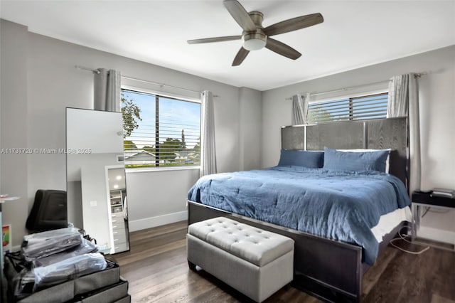 bedroom with multiple windows, hardwood / wood-style floors, and ceiling fan