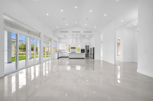 unfurnished living room featuring a towering ceiling and french doors