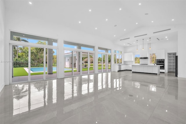 unfurnished living room with a towering ceiling