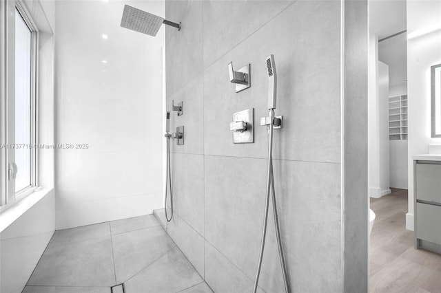 bathroom featuring tiled shower and vanity