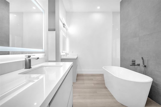 bathroom featuring vanity, a bath, and hardwood / wood-style floors