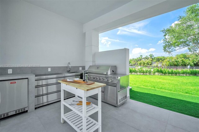 kitchen with pendant lighting, sink, a kitchen island with sink, a towering ceiling, and white cabinets