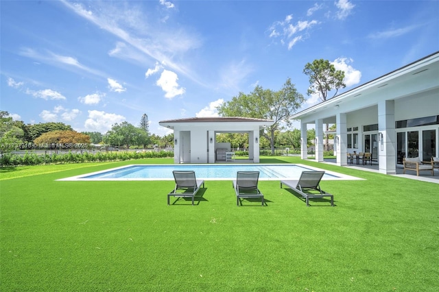 view of swimming pool with an outdoor structure and a yard