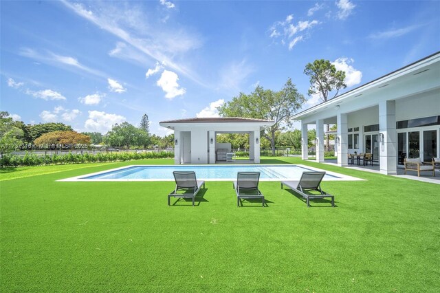 view of pool featuring area for grilling, a yard, and a patio area