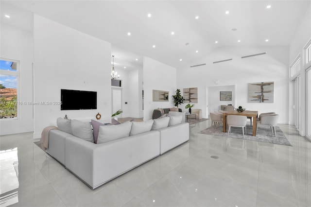 living room with an inviting chandelier and high vaulted ceiling