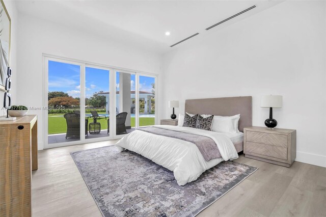 bedroom with access to exterior and light wood-type flooring