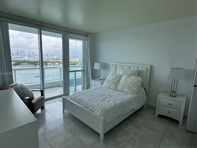 bedroom featuring floor to ceiling windows, a water view, light tile patterned floors, and access to exterior