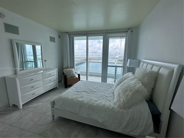 bedroom with a water view, multiple windows, and access to outside