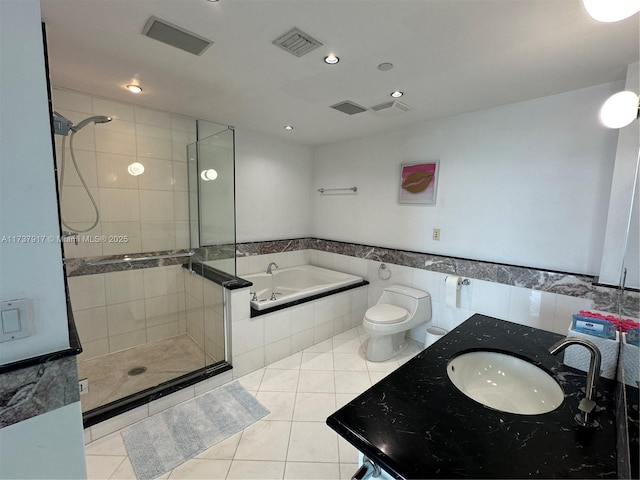 full bathroom with tile patterned flooring, tile walls, vanity, independent shower and bath, and toilet