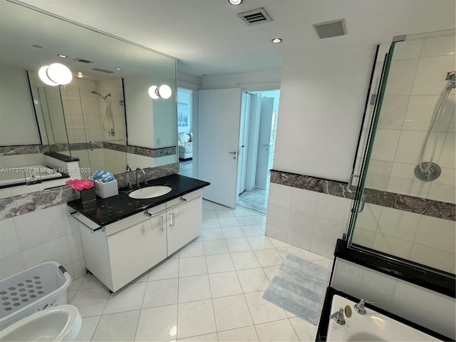 bathroom with tiled shower, tile walls, a bidet, vanity, and tile patterned flooring