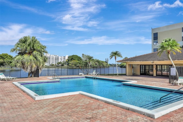 view of pool featuring a patio and a water view