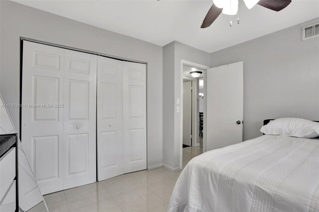 bedroom with ceiling fan, a closet, and light tile patterned floors