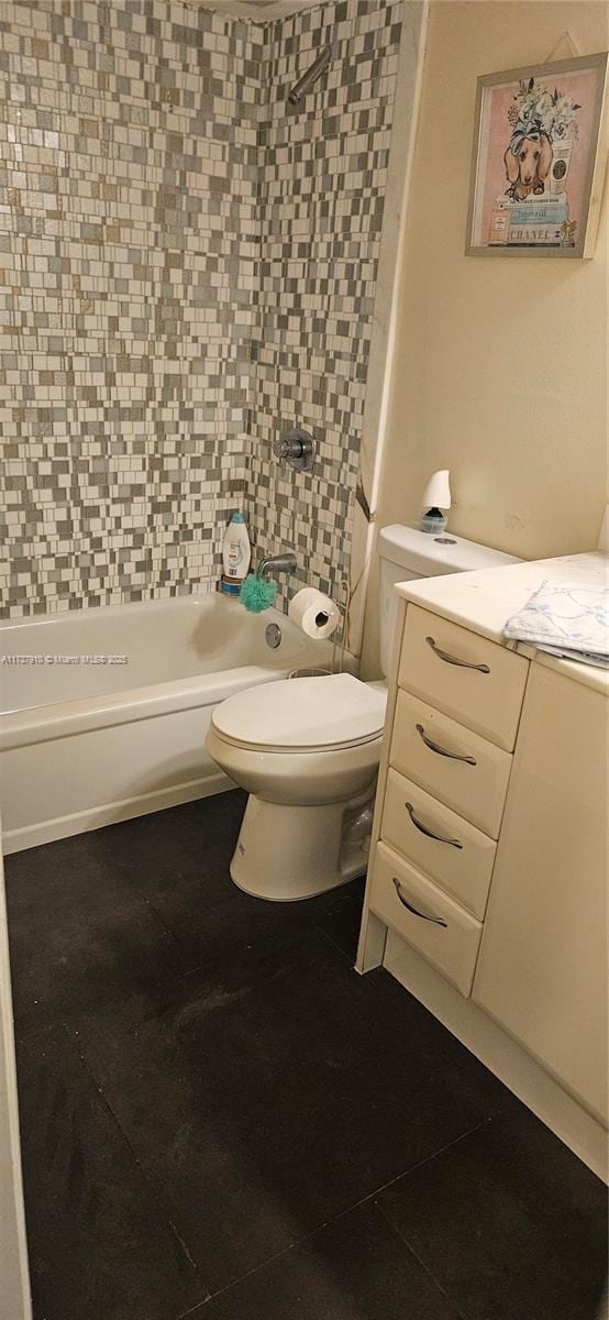 bathroom featuring tile patterned flooring, tiled shower / bath, and toilet