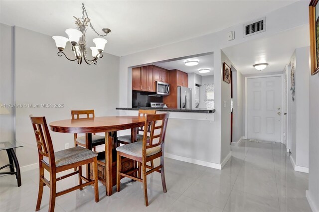 dining space featuring light tile patterned floors and a chandelier