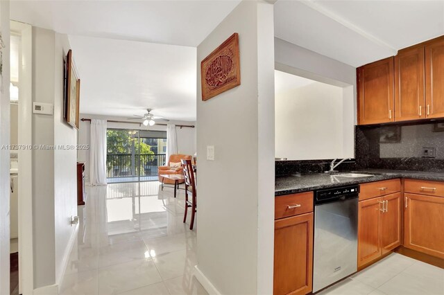 kitchen with dark stone countertops, backsplash, stainless steel dishwasher, and light tile patterned flooring