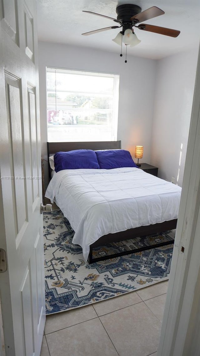 bedroom with ceiling fan and light tile patterned floors