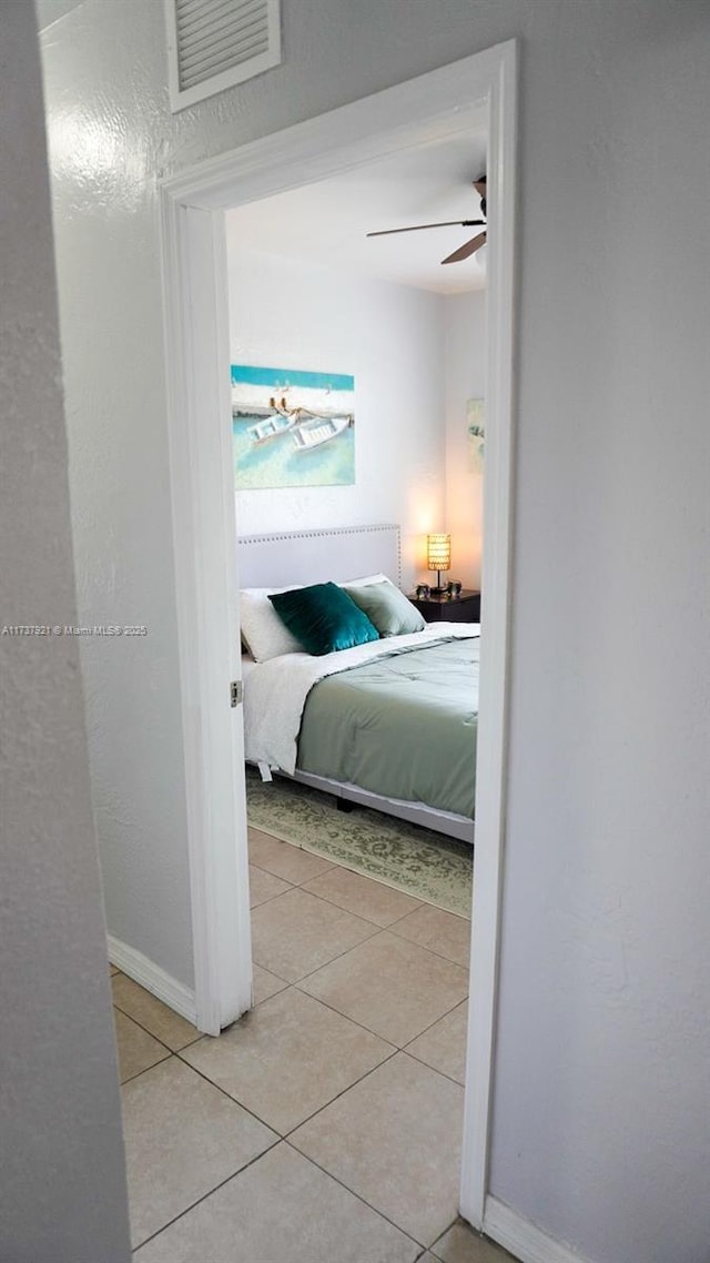 tiled bedroom featuring ceiling fan