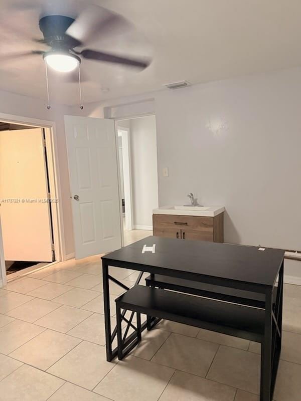 dining area with ceiling fan, sink, and light tile patterned floors