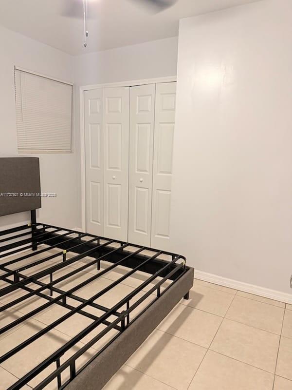 tiled bedroom with a closet