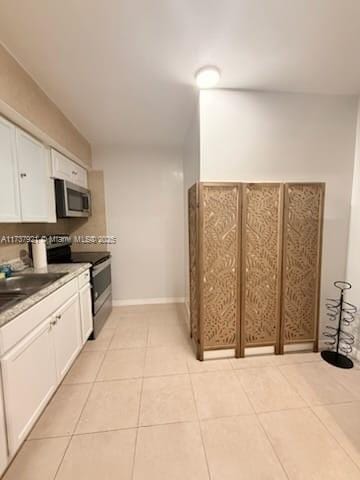 kitchen with white cabinetry, appliances with stainless steel finishes, and light tile patterned floors