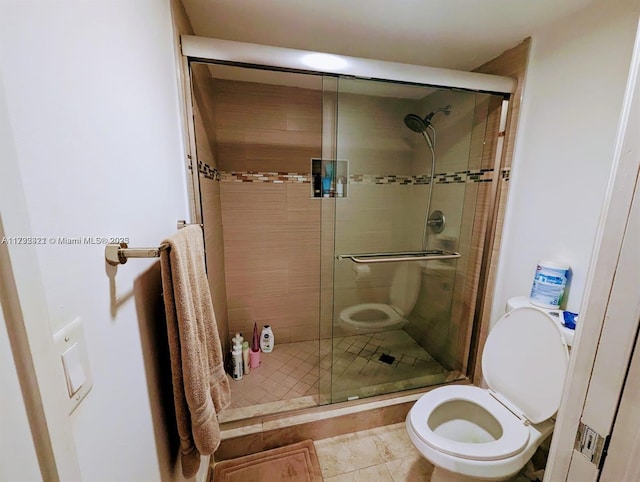 bathroom with toilet, tile patterned floors, and walk in shower