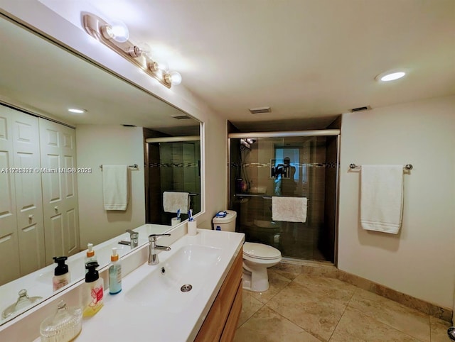 bathroom with tile patterned floors, vanity, toilet, and a shower with door