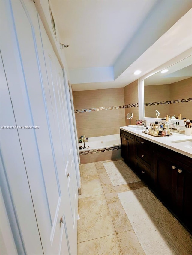 bathroom featuring vanity, tile patterned floors, and tiled bath