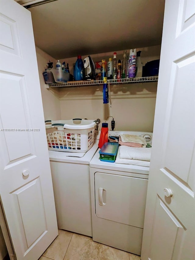 clothes washing area with light tile patterned floors and independent washer and dryer