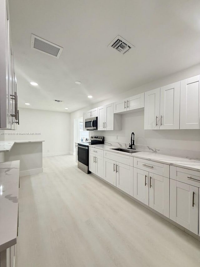 kitchen featuring white cabinetry, visible vents, appliances with stainless steel finishes, and a sink