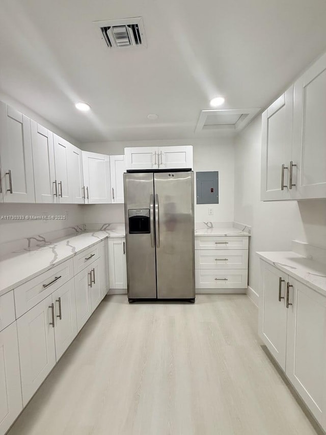 kitchen with visible vents, stainless steel refrigerator with ice dispenser, and white cabinetry