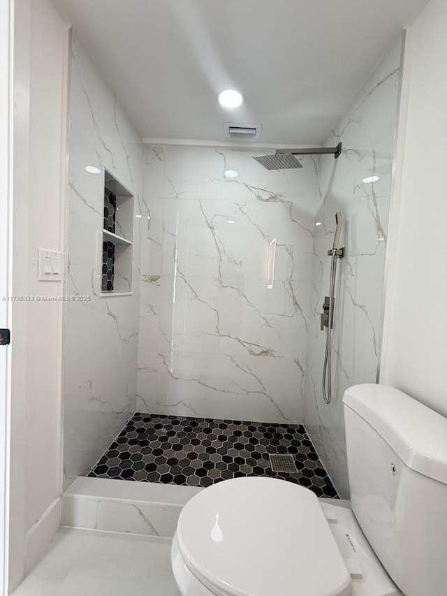 bathroom featuring a marble finish shower, visible vents, marble finish floor, and toilet