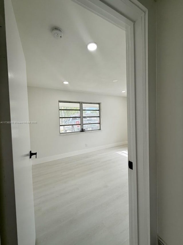 unfurnished room with light wood finished floors, recessed lighting, and baseboards