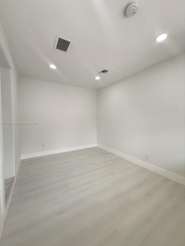 unfurnished room with light wood finished floors, baseboards, and visible vents