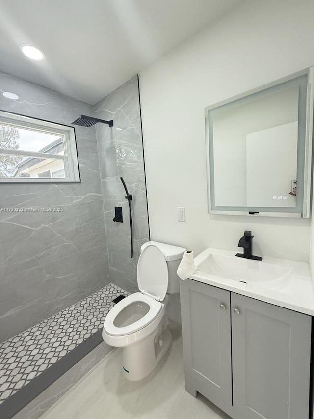 full bath featuring toilet, vanity, and a shower stall