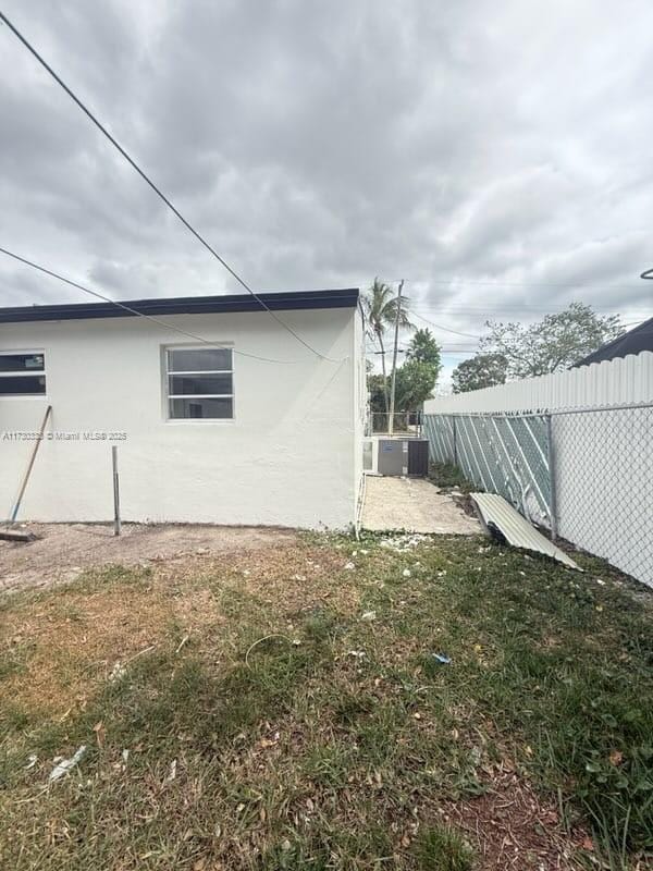 view of side of home featuring fence and stucco siding