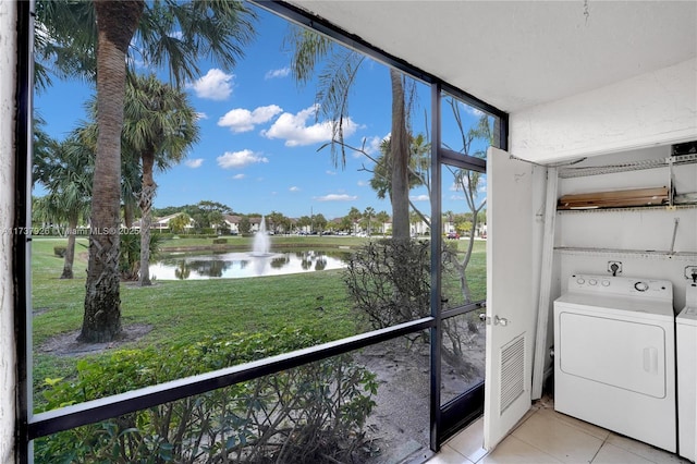 washroom featuring light tile patterned flooring, a water view, and hookup for an electric dryer