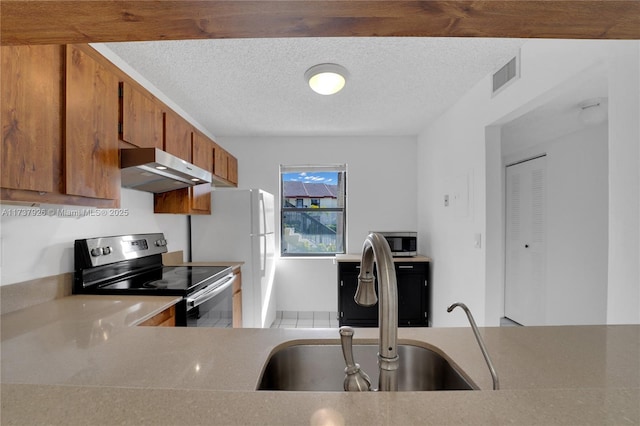 kitchen featuring appliances with stainless steel finishes, sink, and a textured ceiling