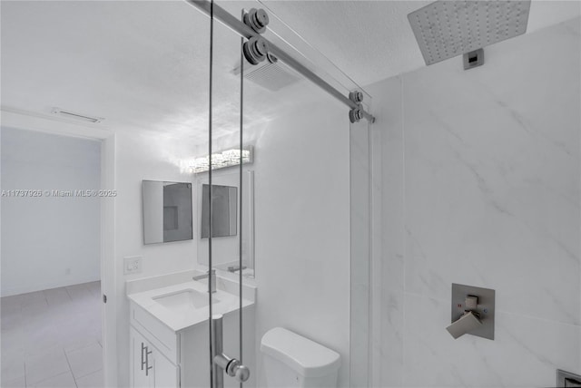 bathroom with vanity, a textured ceiling, a shower with door, and toilet