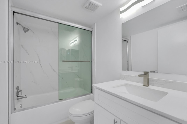 full bathroom with bath / shower combo with glass door, vanity, and toilet