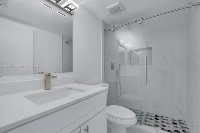 bathroom featuring vanity, toilet, and a shower with shower door