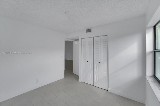 unfurnished bedroom with a closet and a textured ceiling