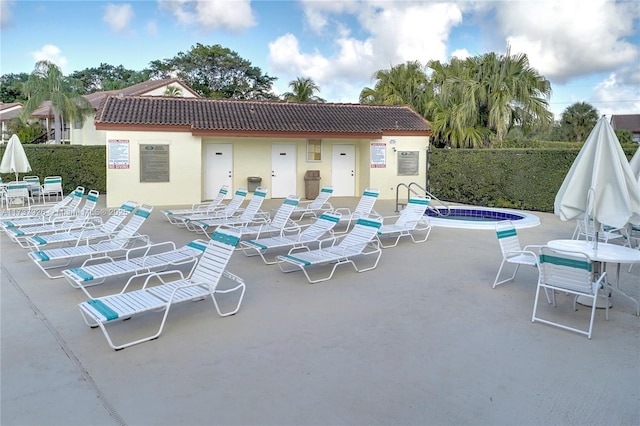 view of swimming pool with a hot tub and a patio area