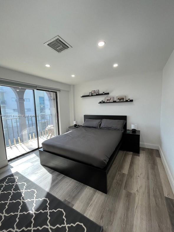 bedroom with wood-type flooring and access to exterior