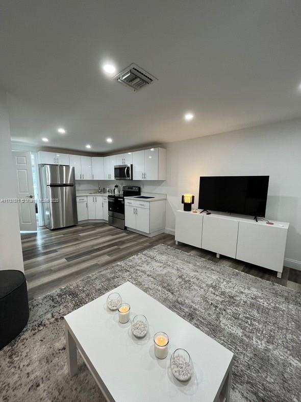 living room featuring dark hardwood / wood-style floors and sink