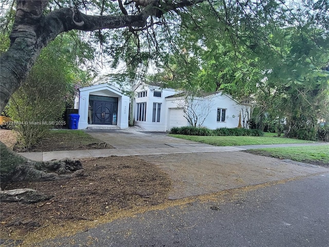 view of front of house featuring a garage and a front lawn