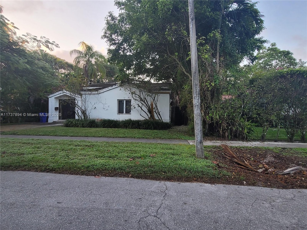 property exterior at dusk with a lawn