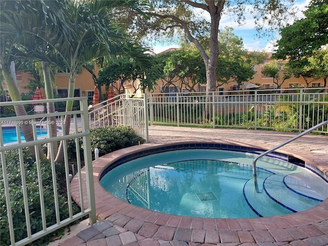 view of swimming pool with an in ground hot tub