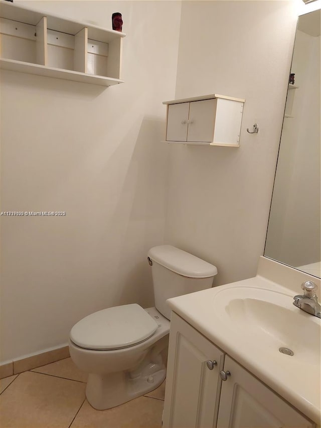 bathroom with tile patterned flooring, vanity, and toilet