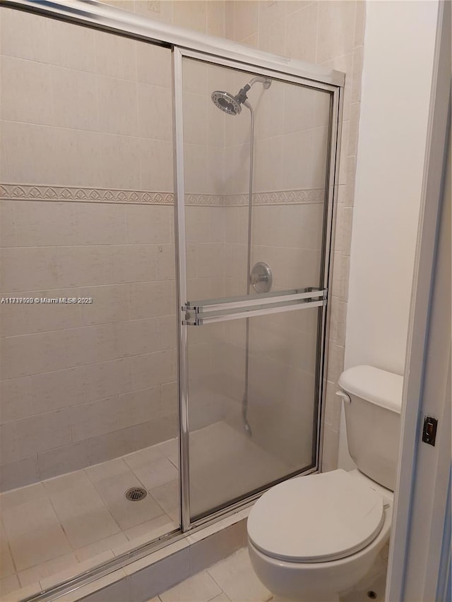 bathroom with tile patterned flooring, an enclosed shower, and toilet